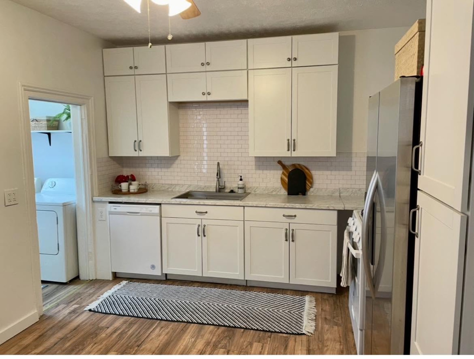 Newly renovated kitchen with white cabinetry, subway tile backsplash and stainless steel appliances